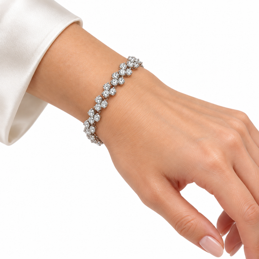 Famous rhodium plated bracelet with repeating three-stone links worn on a wrist on white