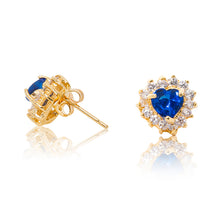 Load image into Gallery viewer, A beautiful tribute to the heart. Delicate 18ct yellow gold plated studs with blue cubic zirconia stones framing a subtle red heart at the centre. Side view (Butterfly and pole closure)
