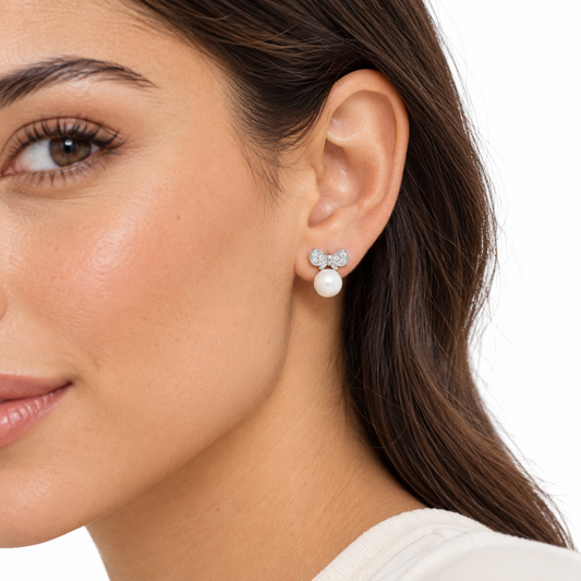 Arabella pearl and silver bow earrings worn by a model