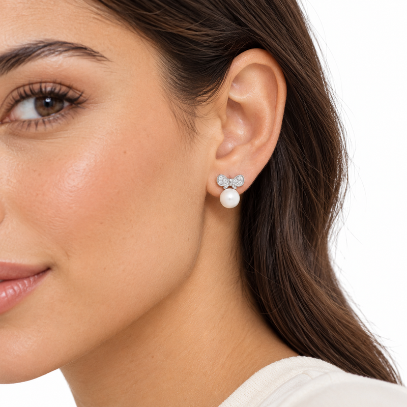 Arabella pearl and silver bow earrings worn by a model