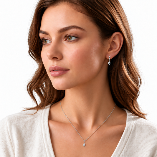 Model wearing delicate Celyn silver twist necklace and matching earrings on a white background