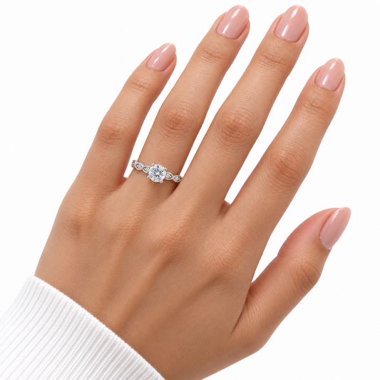 Verity sterling silver solitaire ring worn on a full hand with nude pink nails against a white background