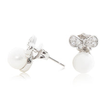 Load image into Gallery viewer, An elegant pair of stud faux pearl earrings finished with rhodium plating and cubic zirconia encrusted bows side view (butterfly and pole closure)
