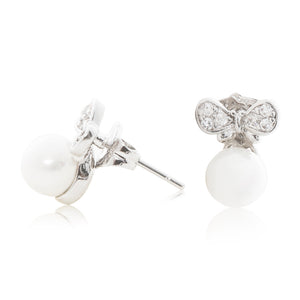 An elegant pair of stud faux pearl earrings finished with rhodium plating and cubic zirconia encrusted bows side view (butterfly and pole closure)