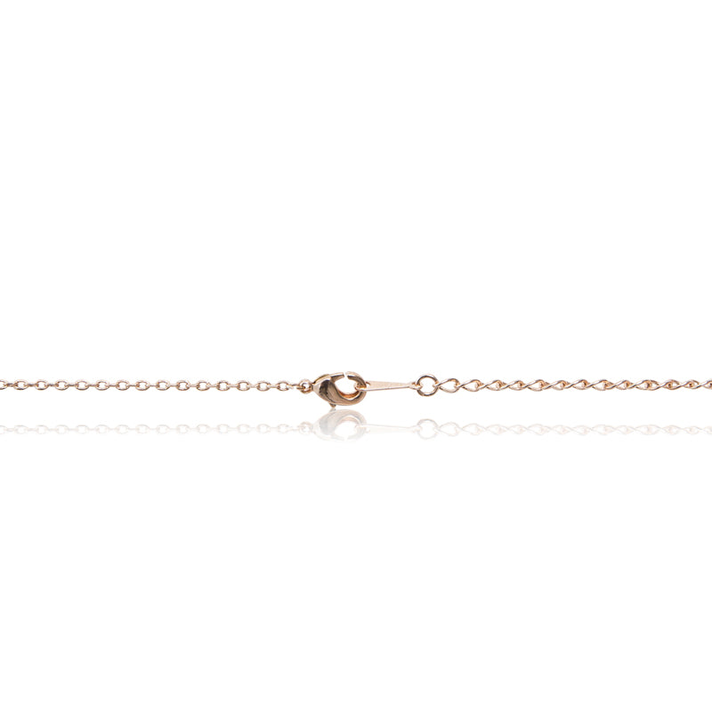 A rose gold, blood red faux ruby cushion centre stone framed in cubic zirconia pendant and chain. Trigger clasp chain closure