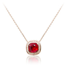 Load image into Gallery viewer, A rose gold, blood red faux ruby cushion centre stone framed in cubic zirconia pendant and chain.
