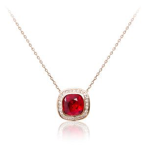 A rose gold, blood red faux ruby cushion centre stone framed in cubic zirconia pendant and chain.