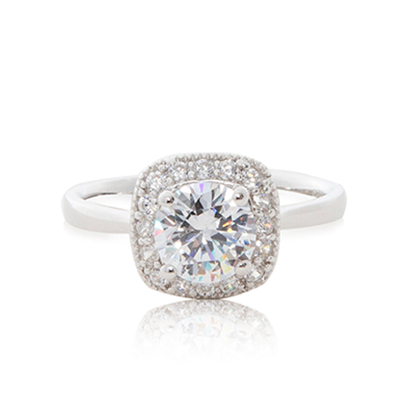 A striking round brilliant cubic zirconia stone surrounded by bead-set cubic zirconia stones evoking a cushion cut guise set in a 925 sterling silver ring.