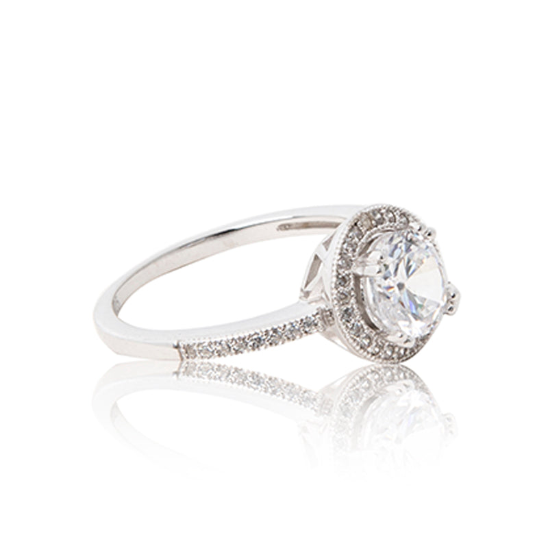 The half eternity halo band. A glamorous round brilliant cut cubic zirconia ring set in 925 sterling silver with a halo of bead-set cubic zirconia stones. Side shank view